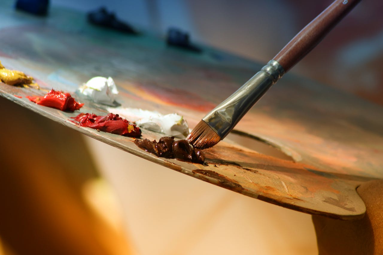 about-us Vibrant artist palette with paint and brush creating colorful artwork.
