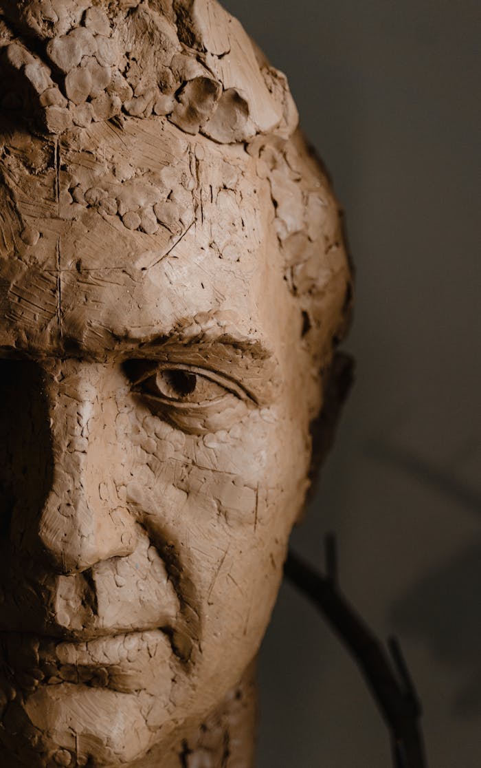 Close-up view of a detailed clay sculpture head with intricate carved features.